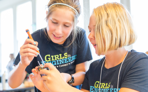 two girls working together with tools